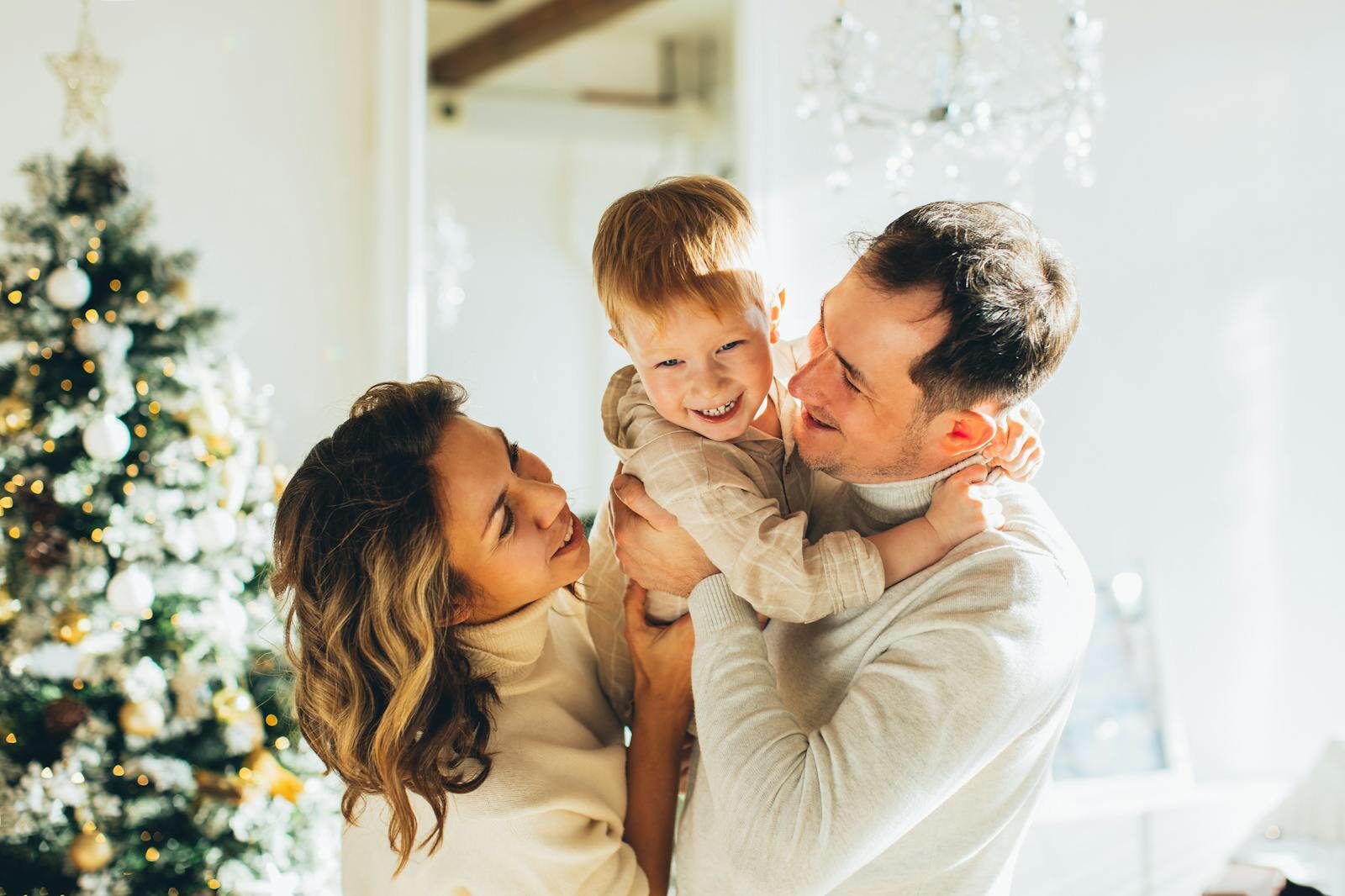 Joyful family bonding by the Christmas tree, enjoying festive moments.